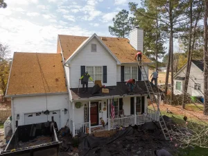 Crew tearing off an old asphalt roof.